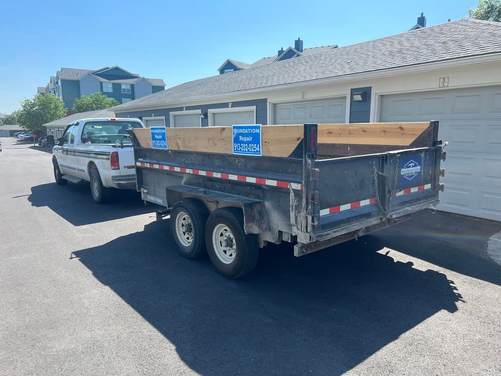 Midwest Basement Solutions dump trailer at a Kansas City job site