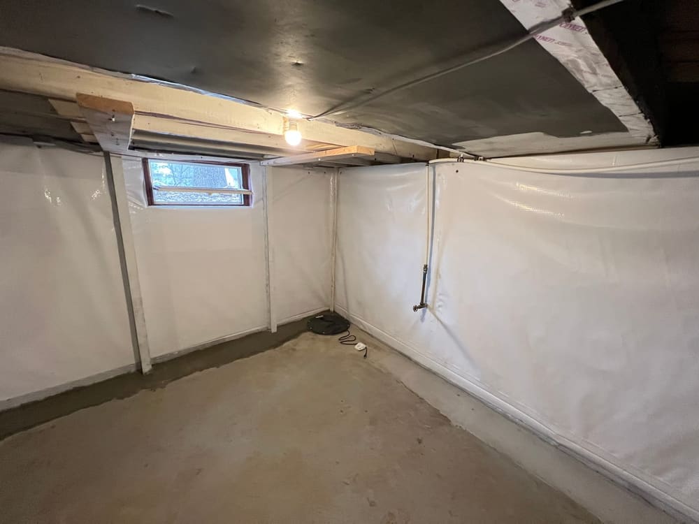 Clean, dry finished basement with vapor-barrier walls after waterproofing