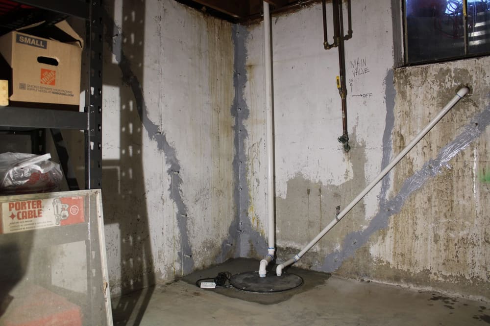 Cracked basement wall with water at the footing before repair