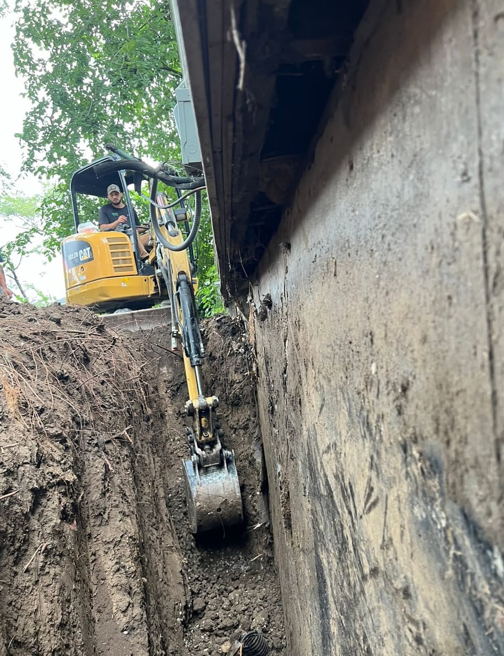Excavation along a foundation wall to install steel push piers