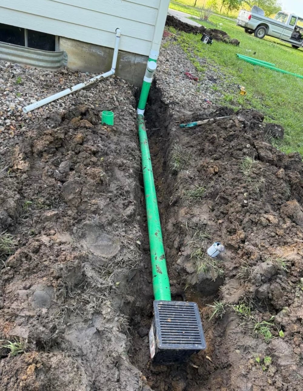 French-drain outlet and downspout tied into an exterior drain box